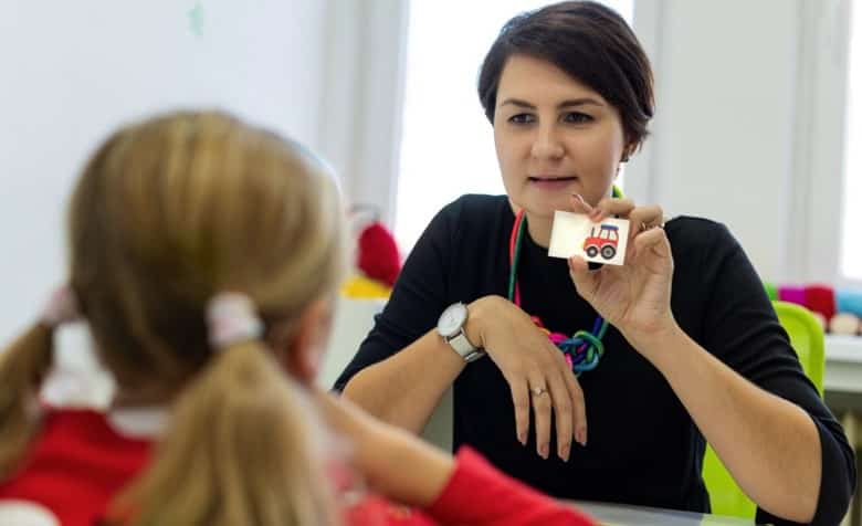 A woman providing cognitive behavioral therapy to a child.