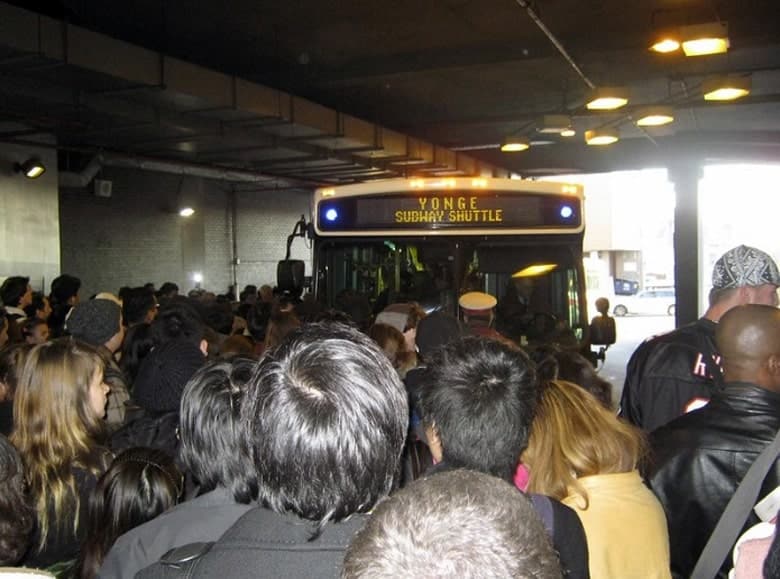 Where will violence happen next? A large crowd of people trying to get on a shuttle bus.