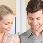 Smiling couple cooking together in a modern kitchen, demonstrating teamwork and positive communication in marriage.