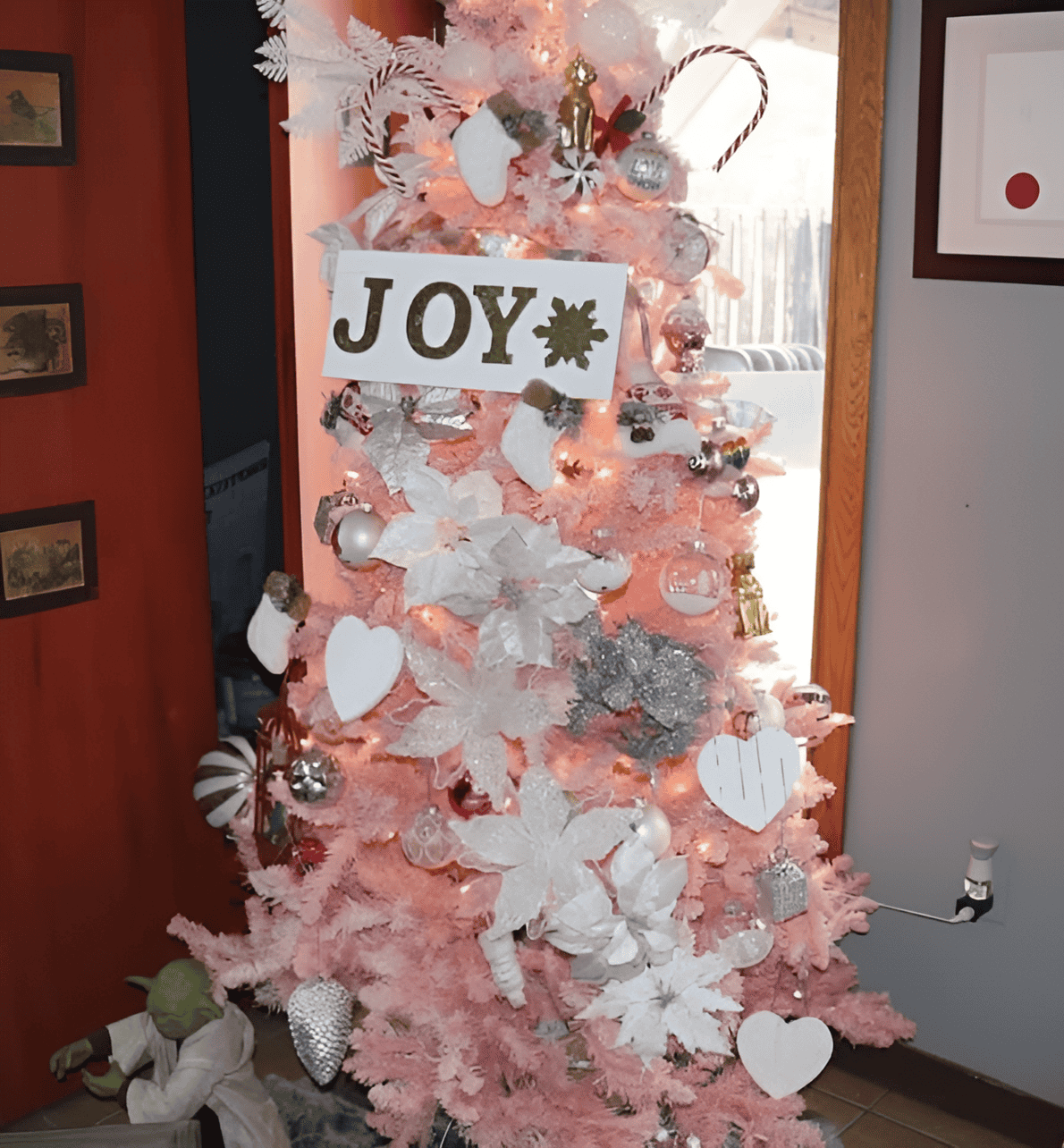Pink tree decorated with white flowers, hearts, and a large “JOY” sign, symbolizing healing and hope, an inviting visual to explore the question: what is AERCS and how can it bring joy to your life?