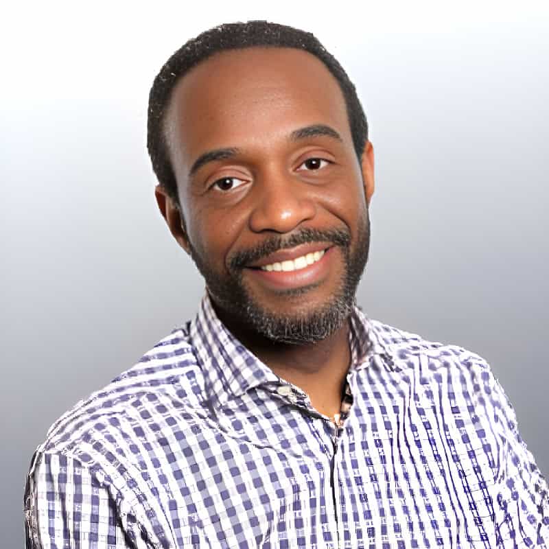 Portrait of Lincoln Skeete smiling in a checkered shirt, representing his compassionate approach to spiritual therapy at AERCS.
