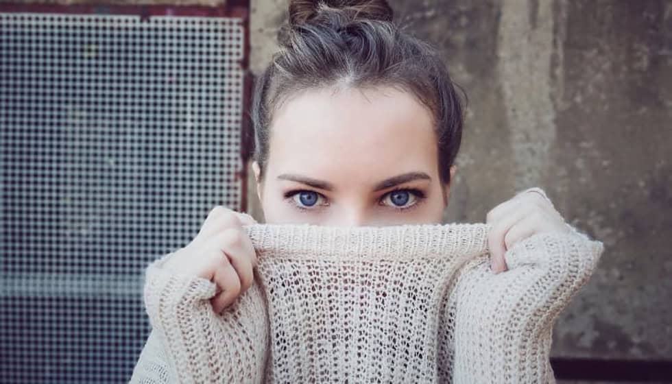 Close-up of a woman’s eyes, partially hiding her face with a sweater, representing emotional healing through EMDR therapy for trauma and PTSD using eye movement. Close-up of a woman’s eyes, partially hiding her face with a sweater, representing emotional healing through EMDR therapy for trauma and PTSD using eye movement.
