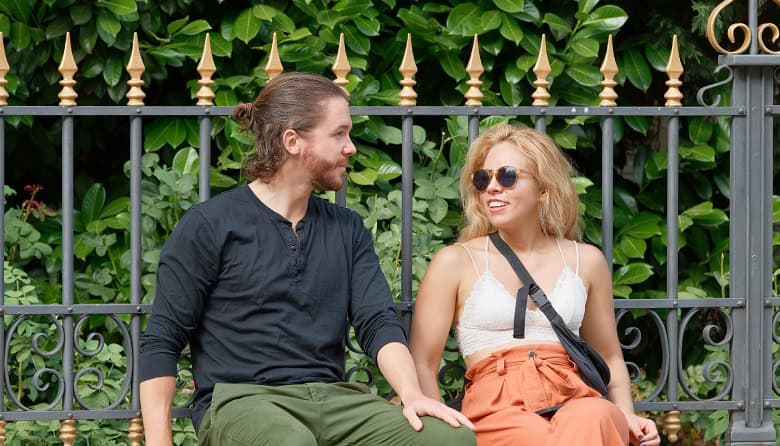 Couple sitting by a park fence having an open conversation, representing relationship healing and the role of infidelity counselling in rebuilding trust. Couple sitting by a park fence having an open conversation, representing relationship healing and the role of infidelity counselling in rebuilding trust.