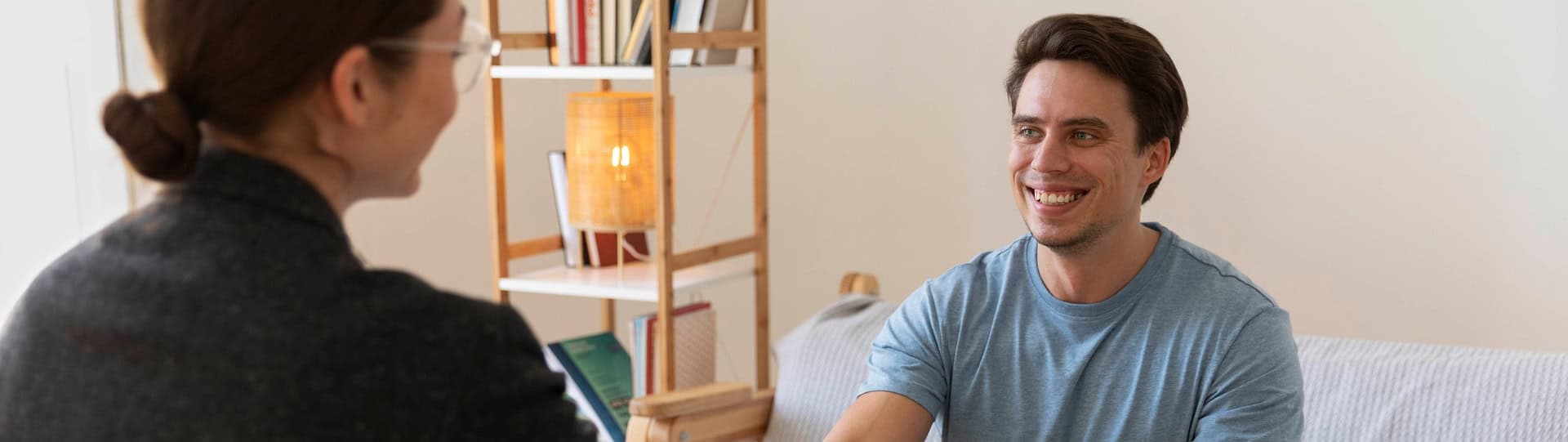 Smiling man engaged in a supportive counselling session, representing the compassionate approach of trauma informed therapy.
