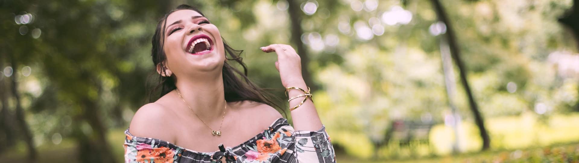Woman laughing joyfully outdoors, symbolizing the emotional relief and confidence that can come from effective anxiety therapy sessions.