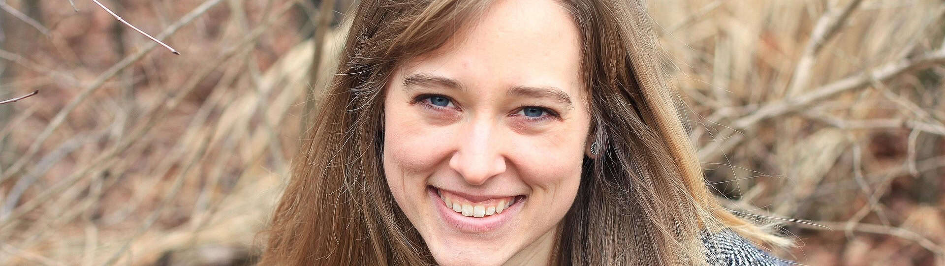 Smiling woman outdoors, representing a sense of relief and emotional well-being after successful anxiety therapy.
