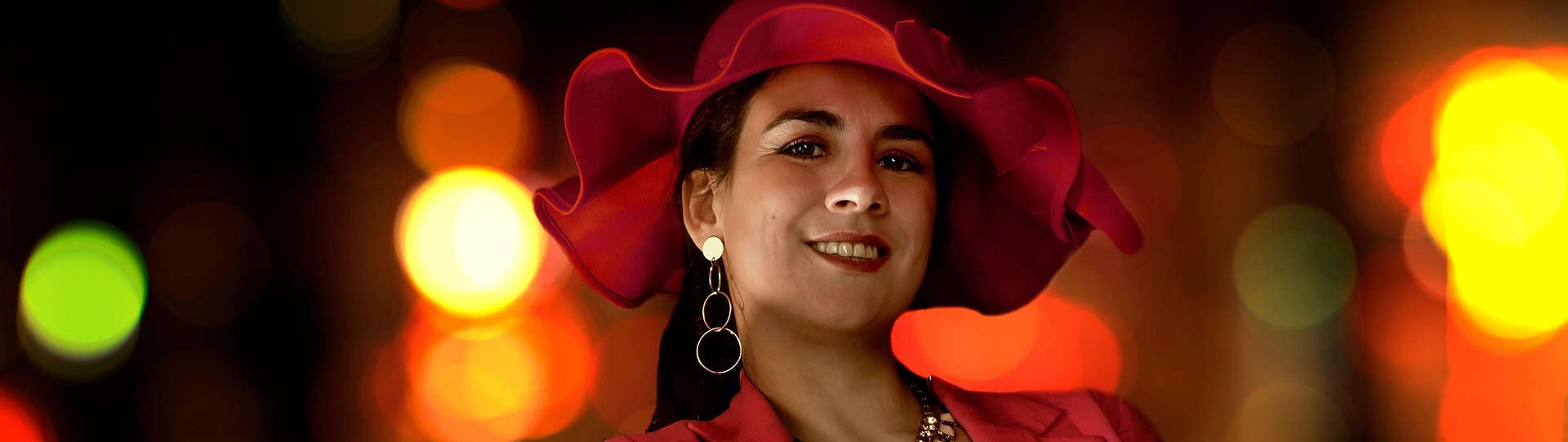 Woman in a red hat smiling confidently, symbolising empowerment and self-assurance after a successful first anxiety therapy session.