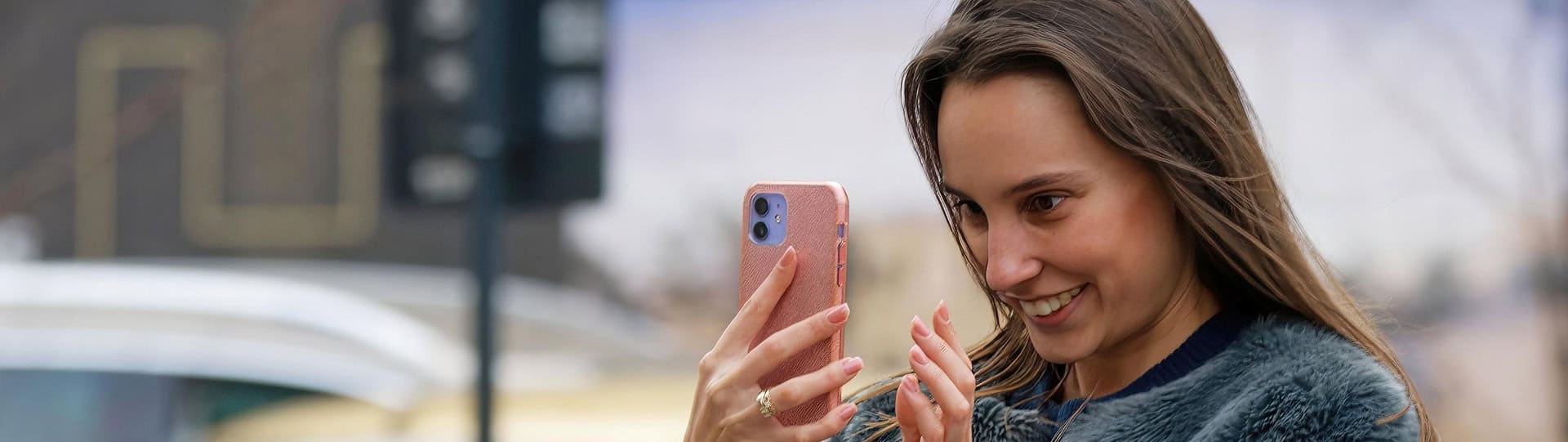 Smiling woman on a video call outdoors, representing connection and support as part of learning how to cope with anxiety through communication and self-care.