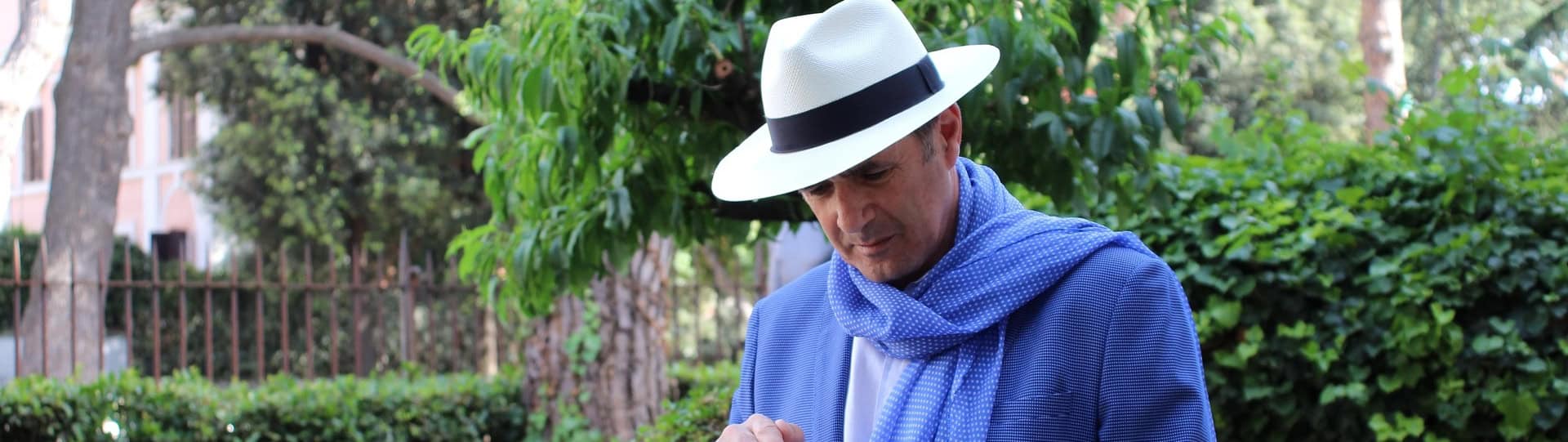 Middle-aged man in a white hat and blue scarf walking outdoors, representing the courage and self-reflection involved in starting anxiety therapy.