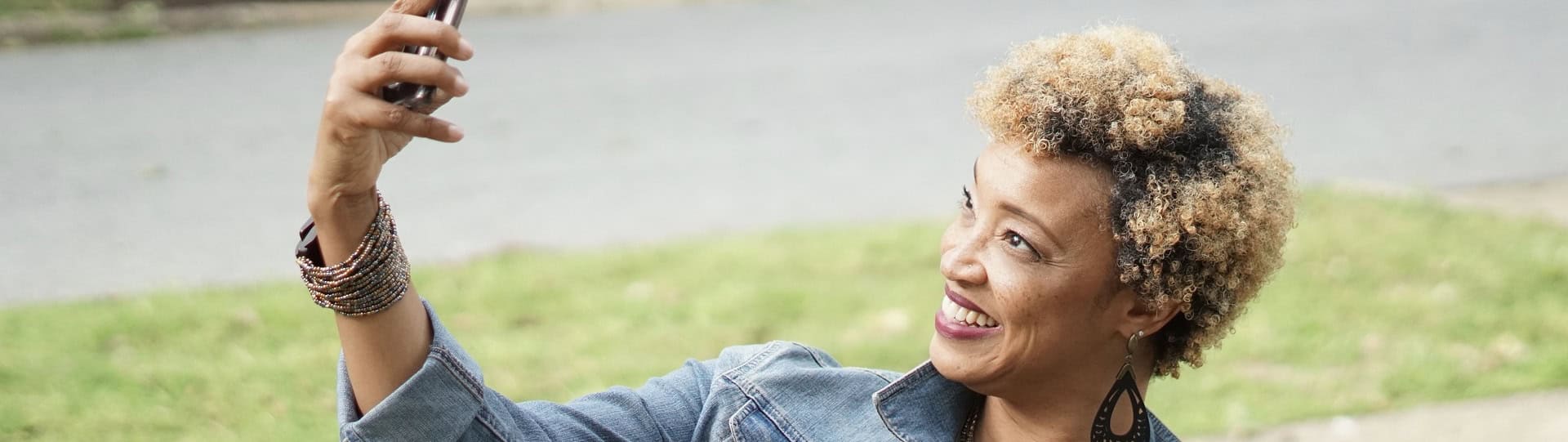 Smiling woman taking a selfie outdoors, symbolising confidence and relief after exploring different types of therapy for anxiety.
